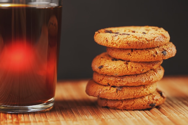 Biscuits à l'avoine avec des morceaux de chocolat et une tasse de thé noir aromatique