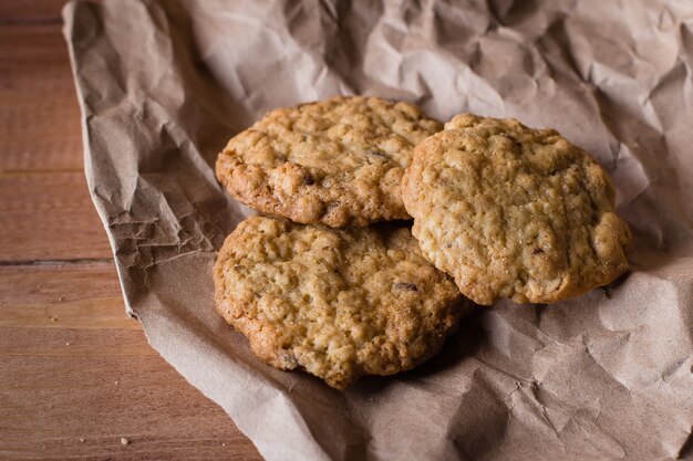 Biscuits à l&#39;avoine sur papier kraft sur fond de table en bois.