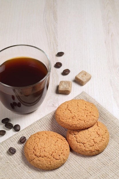 Biscuits à l'avoine et une tasse de café transparente sur une table en bois clair