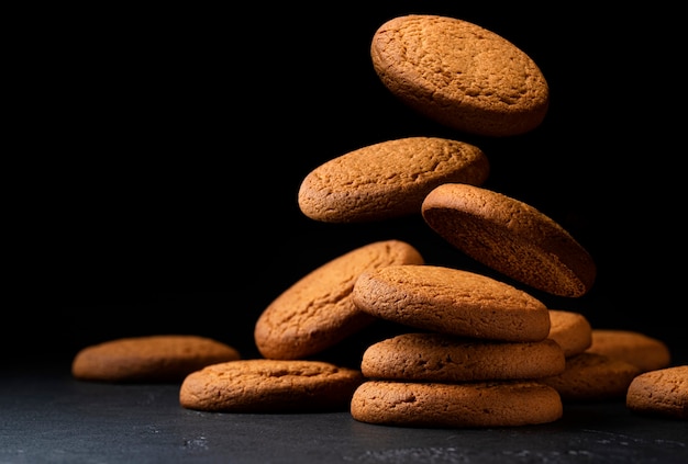 Biscuits à l'avoine tombant sur fond noir