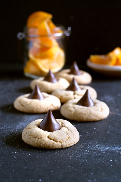 Biscuits avec baiser de bonbons au chocolat, morceaux d'orange tranchés sur fond .