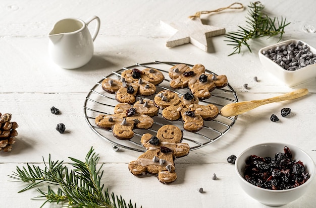 Biscuits de bonhomme en pain d'épice faits maison avec des canneberges sèches, des gouttes de chocolat et de glaçage au sucre glace