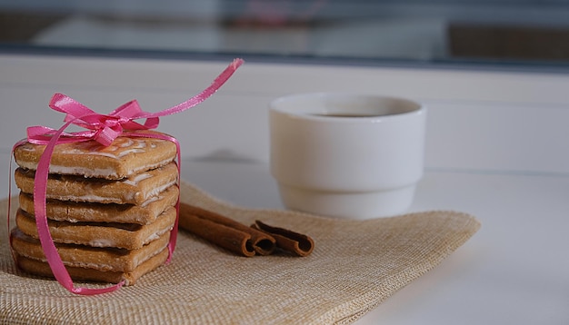 Biscuits à la cannelle faits maison en forme de coeur avec ruban rose pour la Saint-Valentin