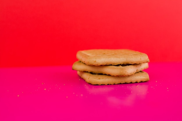 Biscuits carrés sur fond rose sur la table