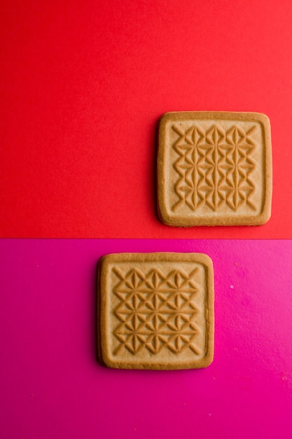 Biscuits carrés sur fond rose sur la table