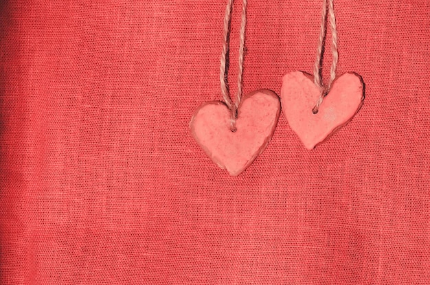 Biscuits coeur rose sur fond de tissu rouge Biscuits colorés de la Saint-Valentin en forme de coeur