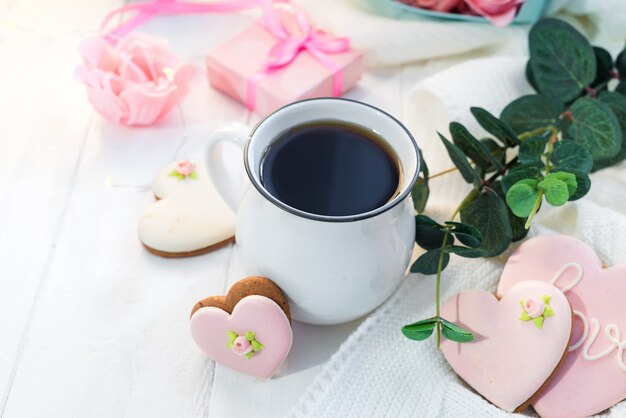 Biscuits coeur avec une tasse de café sur un fond en bois avec plaid, espace copie