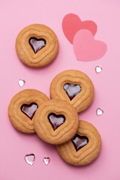 Photo biscuits avec des coeurs sur une surface rose