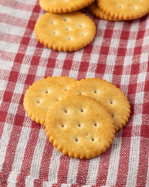 Biscuits craquelins avec nappe sur fond de table en bois blanc.