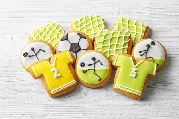 Biscuits créatifs décorés dans le style du football sur fond de bois