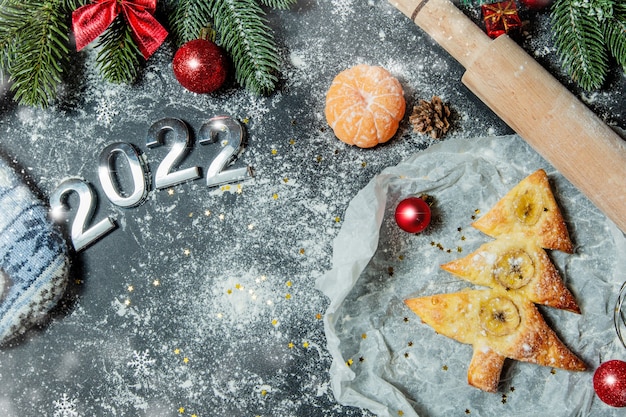 biscuits cuits au four sous la forme d'un arbre de Noël avec des décorations de Noël sur fond noir