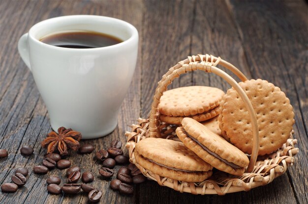 Biscuits dans un panier en osier et tasse de café sur la table