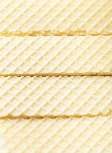 Photo biscuits délicieux et appétissants avec impression à carreaux sur la surface. wafers style sans soudure de fond. gaufres savoureuses ou craquelins. espace de copie. concept de dessert sucré.