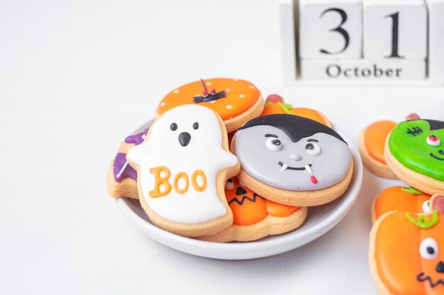 Biscuits drôles d'Halloween avec le calendrier du 31 octobre sur fond blanc. Truc ou menace, joyeux Halloween, bonjour octobre, automne automne, concept festif, fête et vacances