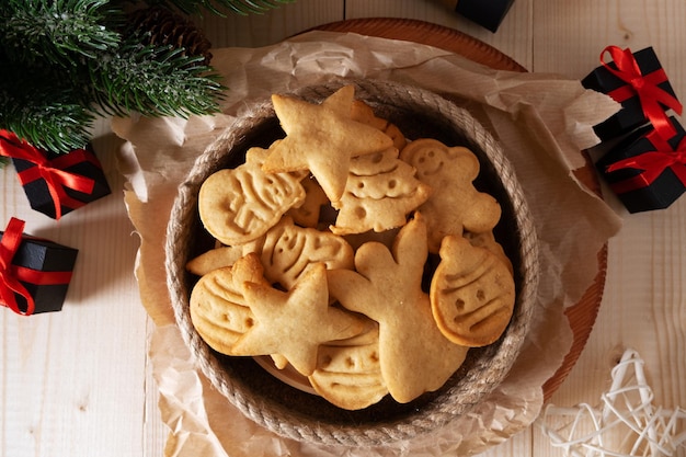 Biscuits du Nouvel An cuits à la maison sous forme de symboles de Noël sur une table en bois
