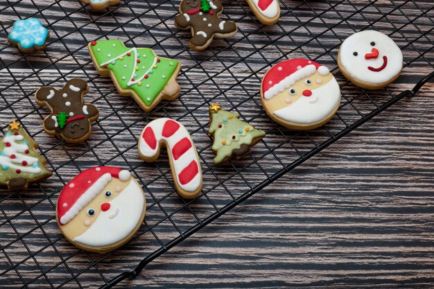 Biscuits enrobés de sucre et biscuits à thème de Noël sur une grille de cuisson