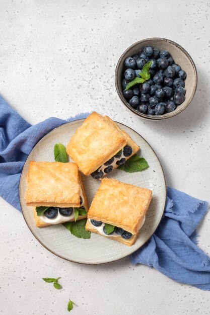 Des biscuits faits maison avec de la crème fouettée et des bleuets.