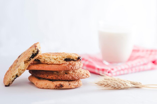 Biscuits faits maison empilés avec un verre de lait et un épi de blé tourné en studio