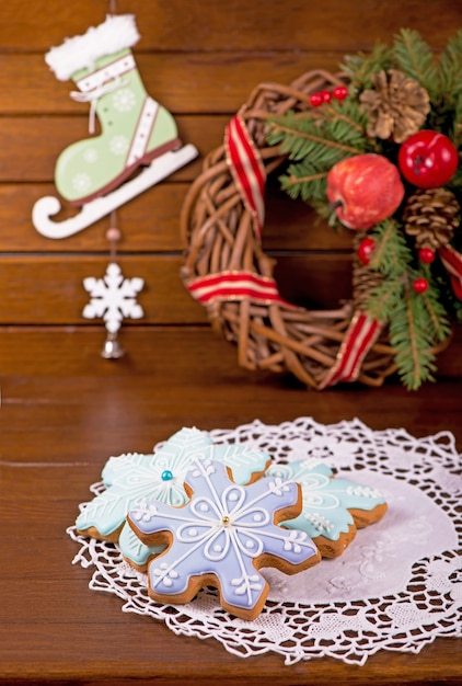 Biscuits faits maison de pain d'épice, bonbons de fête de Noël et de nouvel an sous forme de carte bleue de fond de flocons de neige, sur un conseil en bois