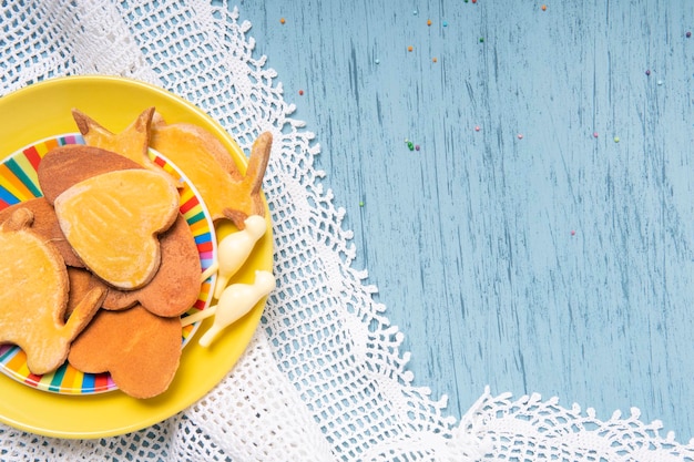 Biscuits faits maison sur une plaque jaune avec nappe en dentelle tricotée sur une table de cuisine