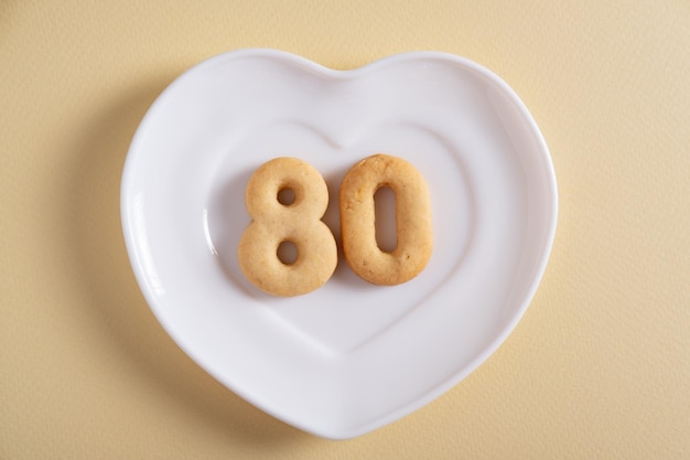 Biscuits formant le numéro 80 sur la plaque blanche et le fond clair jaune