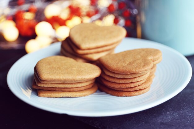 Biscuits en forme de coeur sur assiette et mug sur une table