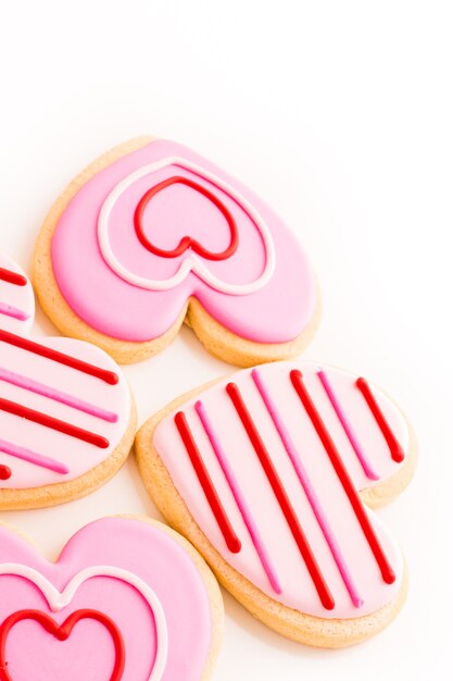 Biscuits en forme de cœur décorés de motifs de glaçage fantaisie.