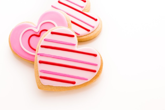 Biscuits en forme de cœur décorés de motifs de glaçage fantaisie.