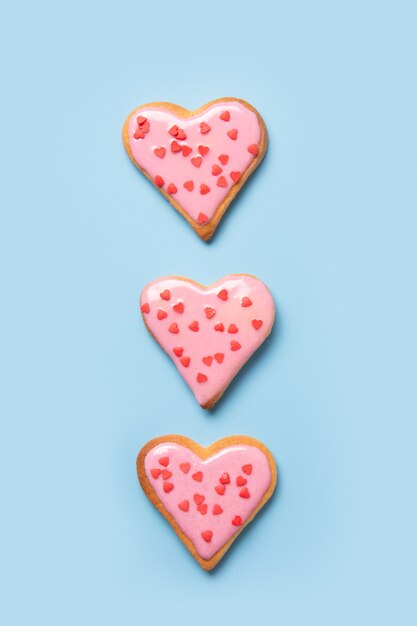 Biscuits en forme de coeur faits maison sur tableau blanc.