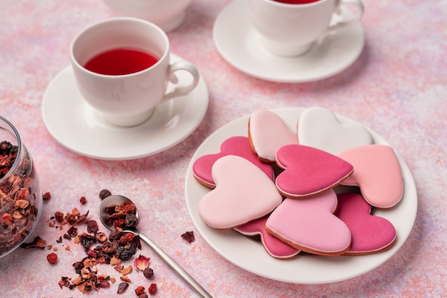 Biscuits en forme de coeur avec glaçage au thé aux baies. Concept: Tea Party de la Saint-Valentin, table de fête en rose.