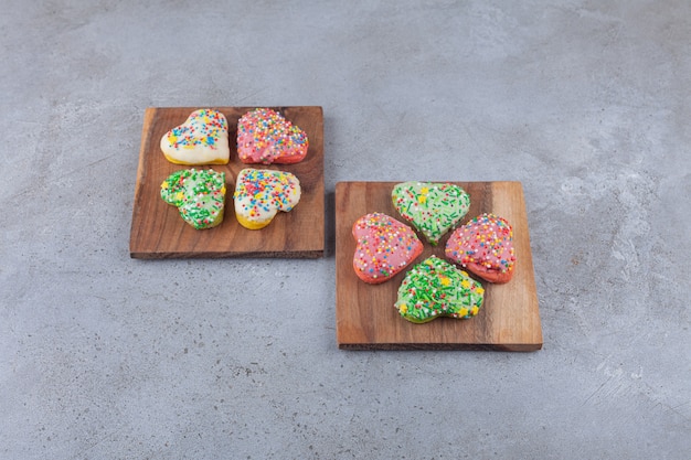 Biscuits En Forme De Coeur Avec Des Paillettes Colorées Placées Sur Une Planche De Bois.