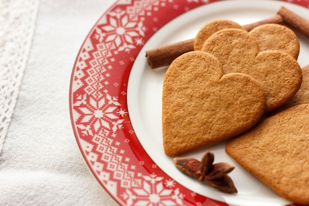 Biscuits en forme de coeur de pain d&#39;épice avec des bâtons de cannelle et des étoiles d&#39;anis