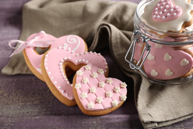 Biscuits en forme de coeur pour la Saint Valentin dans un bocal en verre sur fond de bois