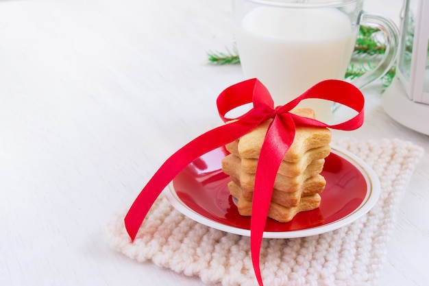 Biscuits en forme d'étoiles et de lait pour le Père Noël sur fond blanc