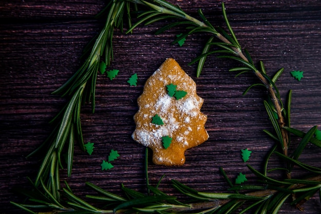 Biscuits en forme de sapin de Noël saupoudrés de sucre en poudre et de petits sapins sur t...