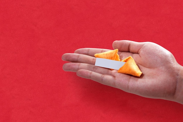 Biscuits de fortune avec une citation vide sur une main humaine avec un fond coloré. Joyeux Nouvel An chinois