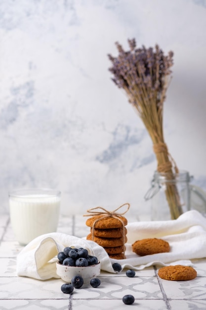 Biscuits frais à l'avoine des grands-mères avec du lait et des baies sur une serviette en lin dans le village