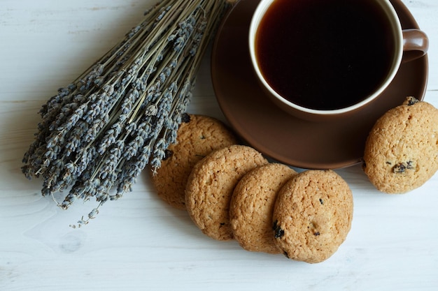 Biscuits à la lavande et tasse de thé sur fond de bois blanc