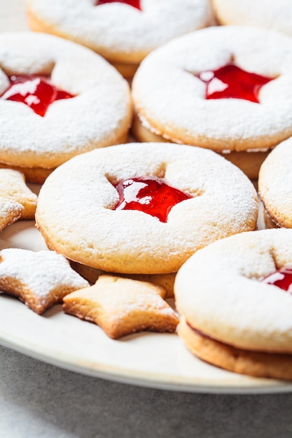 Photo biscuits linzer aux fraises de noël sur fond gris dessert festif friandise d'hiver
