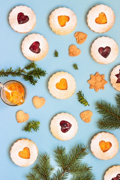 Biscuits Linzer Noël ou du nouvel an remplis de confiture sur fond de papier bleu.