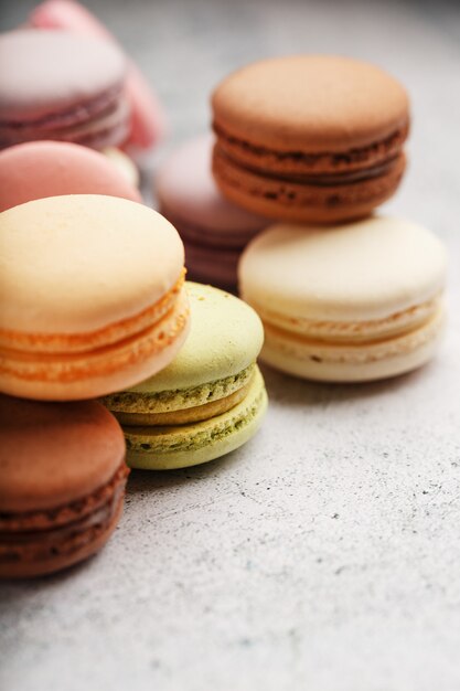 Des biscuits macaroni français de différentes couleurs sont sur la table grise. Nature morte de confiserie.