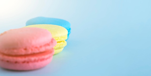 Photo biscuits macarons français colorés macarons sur fond bleu dessert bonbons végétariens bouchent