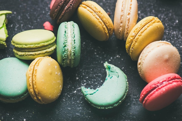 Biscuits macarons français colorés sucrés sur fond noir