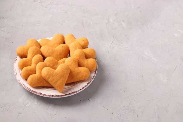 Biscuits maison en forme de coeur sur une assiette sur un fond gris clair