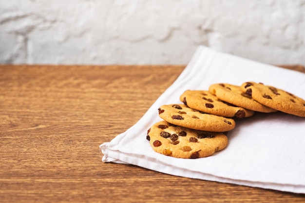 Biscuits maison savoureux parfumés avec des raisins secs sur de la toile de jute brune sur la table