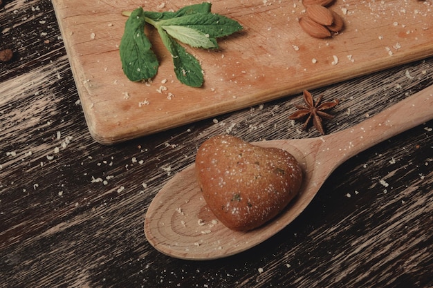 Biscuits à la menthe en forme de coeur sur planche brune biscuits au pain d'épice mise en page des biscuits esthétique de la romance de vacances saint valentin petit déjeuner ensemble planche brune et pain d'épice brun