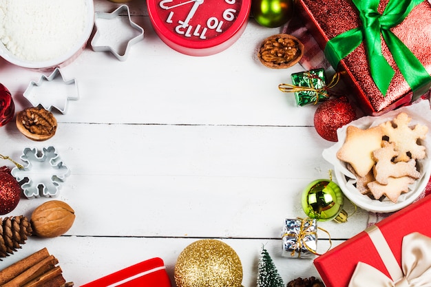 Biscuits de Noël et cadeaux sur fond en bois blanc.