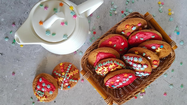 Biscuits de Noël dans un panier et une théière blanche sur fond clair