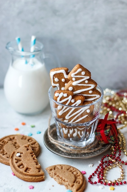 Biscuits de Noël faits maison un sapin dans un verre, une cruche avec du lait sur fond gris