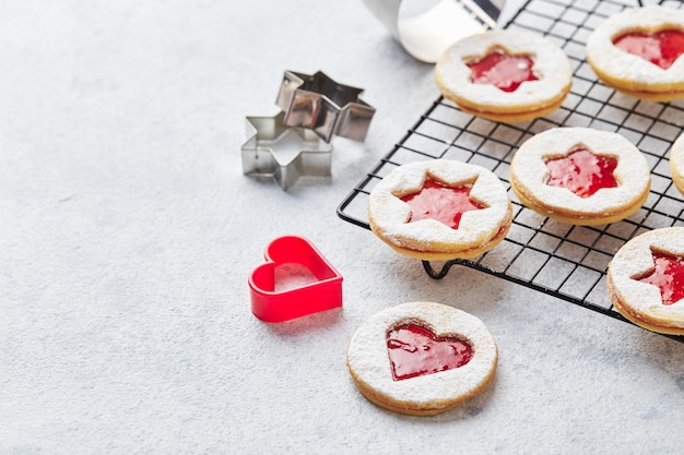 Biscuits de noël linzer classiques avec confiture de framboises ou de fraises sur fond clair